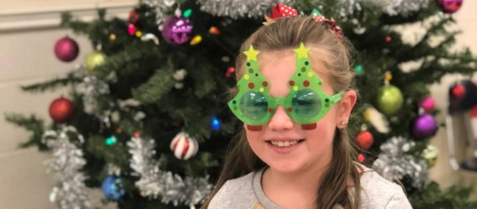 student wearing Christmas tree glasses
