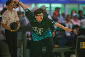 bowler in blue shirt repares to throw
