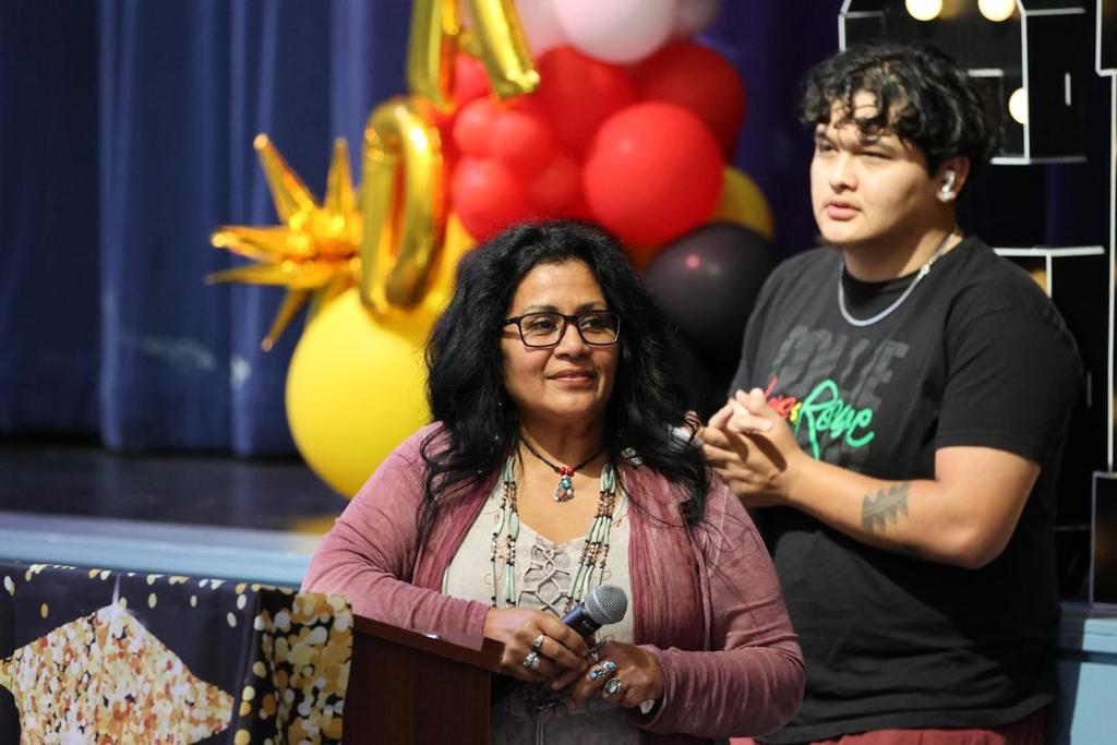 Teacher Buffy stands at podium