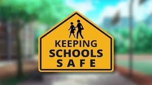 Yellow sign with black lettering  with the words keeping schools safe.