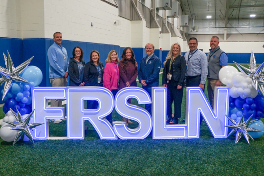 Group stands behind FRSLN light up letters during day-two of the conference
