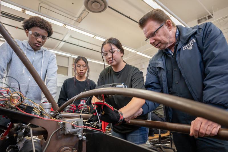 Mr. Marty Supple, Artesia High School automotive teacher, works with students during class.