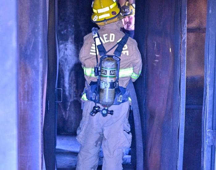 fire science student walking down hall with hose