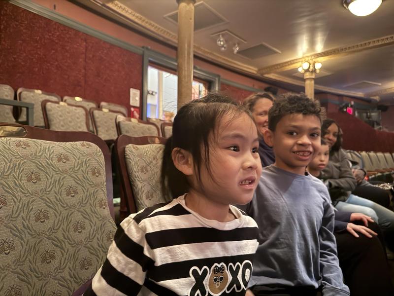 2 students sitting waiting for show at theater