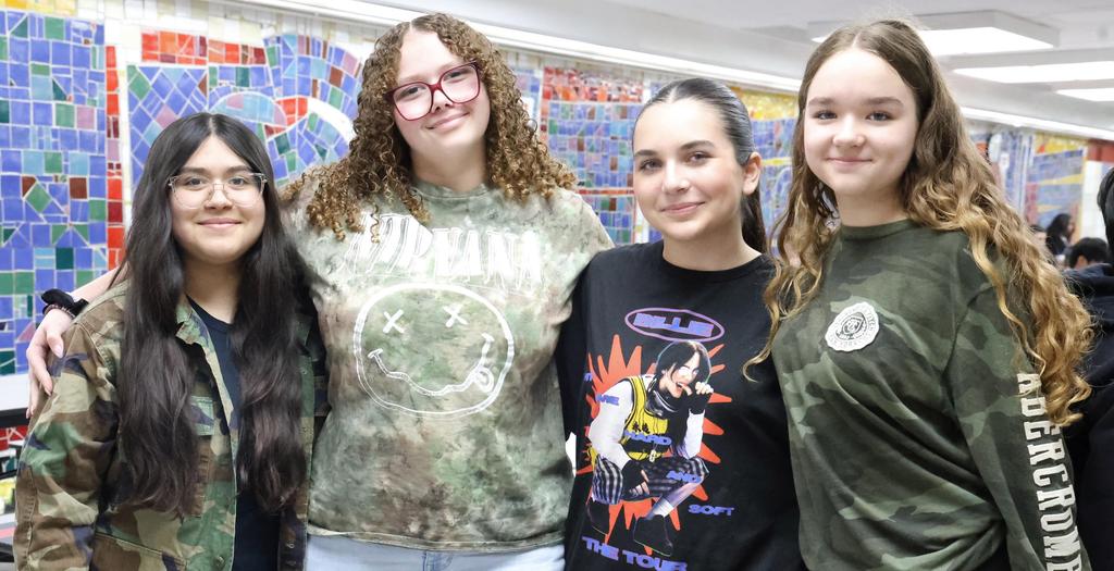 Four girls standing wearing camouflage clothes