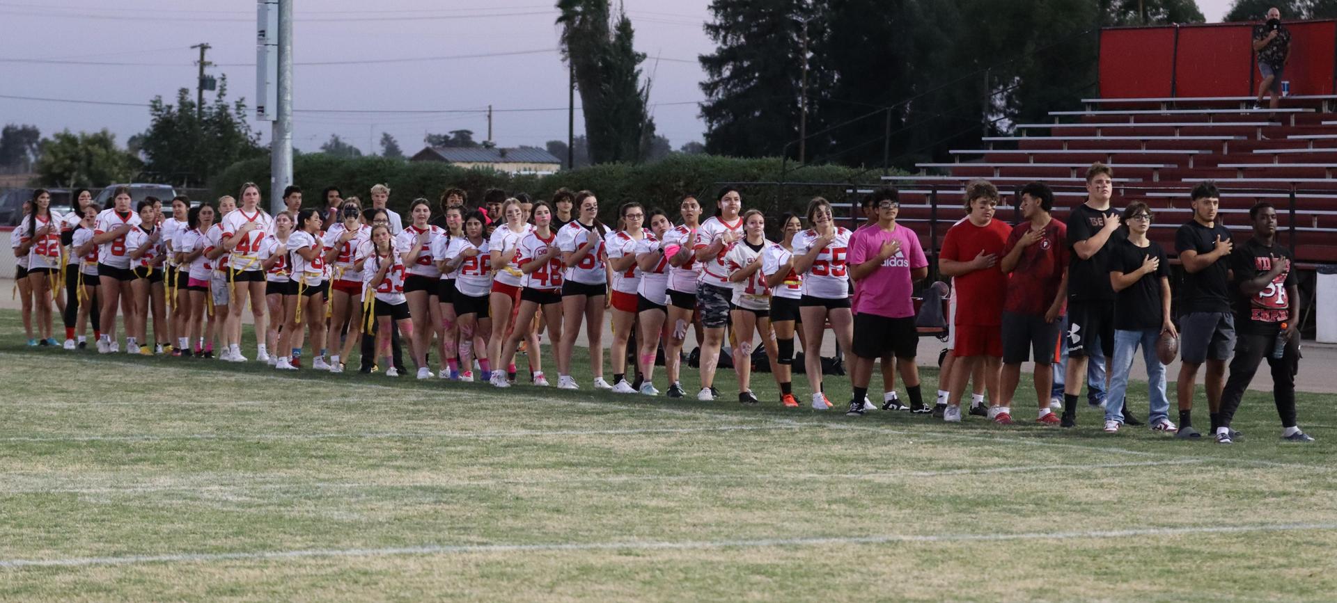 players, cheerleaders, and officials preparing for the powderpuff football game