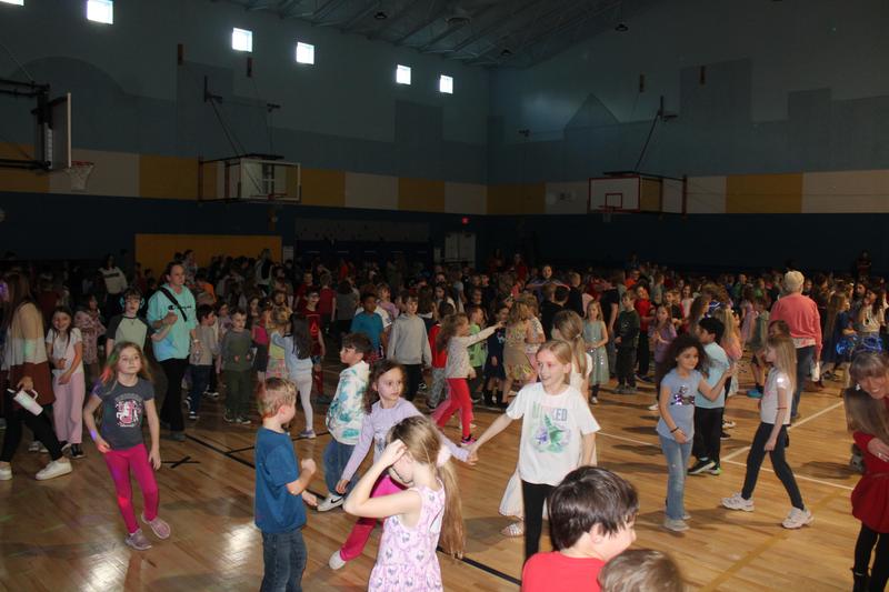 gym filled with elementary school children dancing