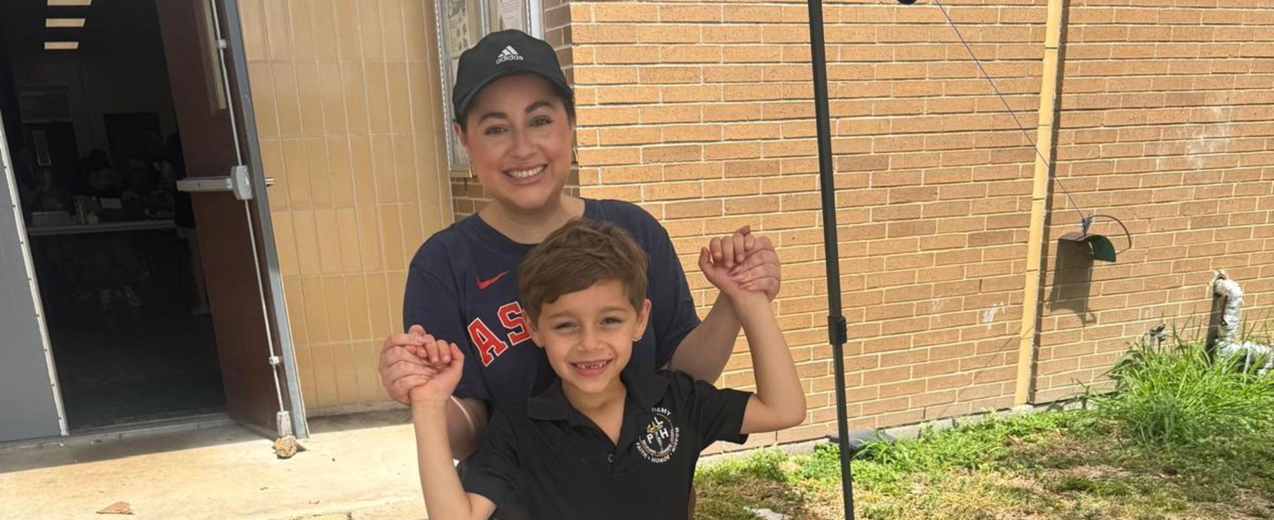 Child posing with a peace sign alongside an adult.
