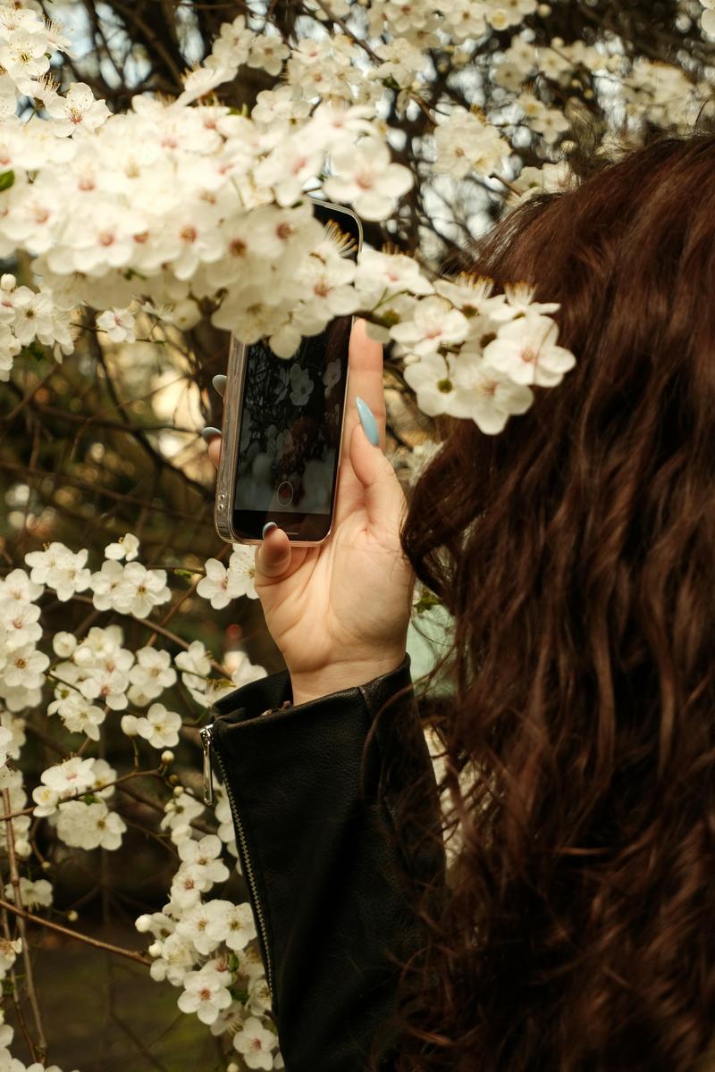 woman taking picture of spring flowers
