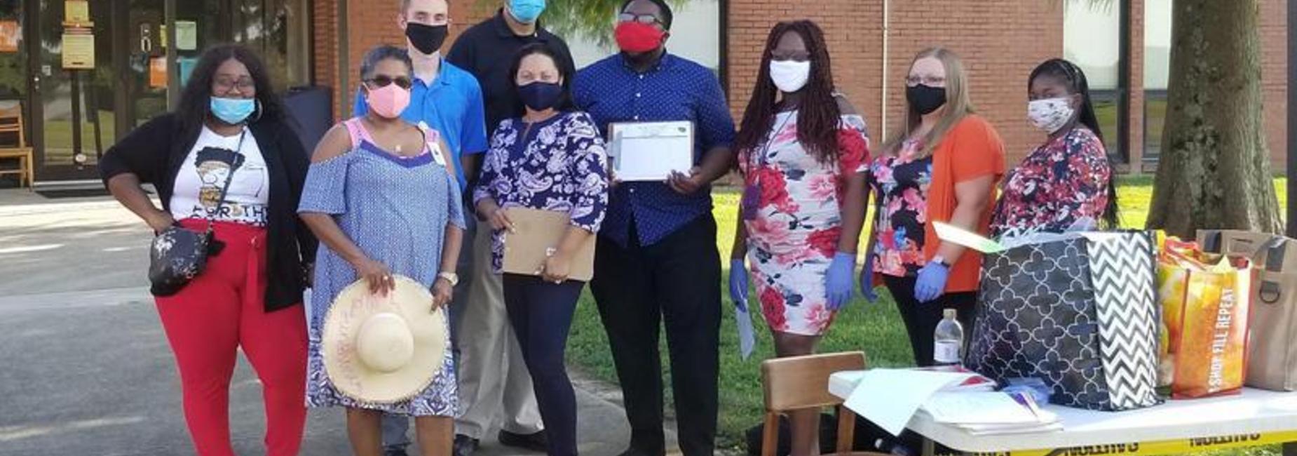 This is a picture of five of the Third Grade staff, the Guidance counselor, the Music teacher, and the Art teacher demonstrating the proper use of covid masks during the first DSJ Open House