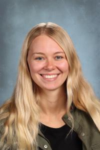 Smiling young woman with long blonde hair in a black shirt.