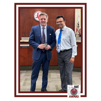Two men posing for a photo in a Board room