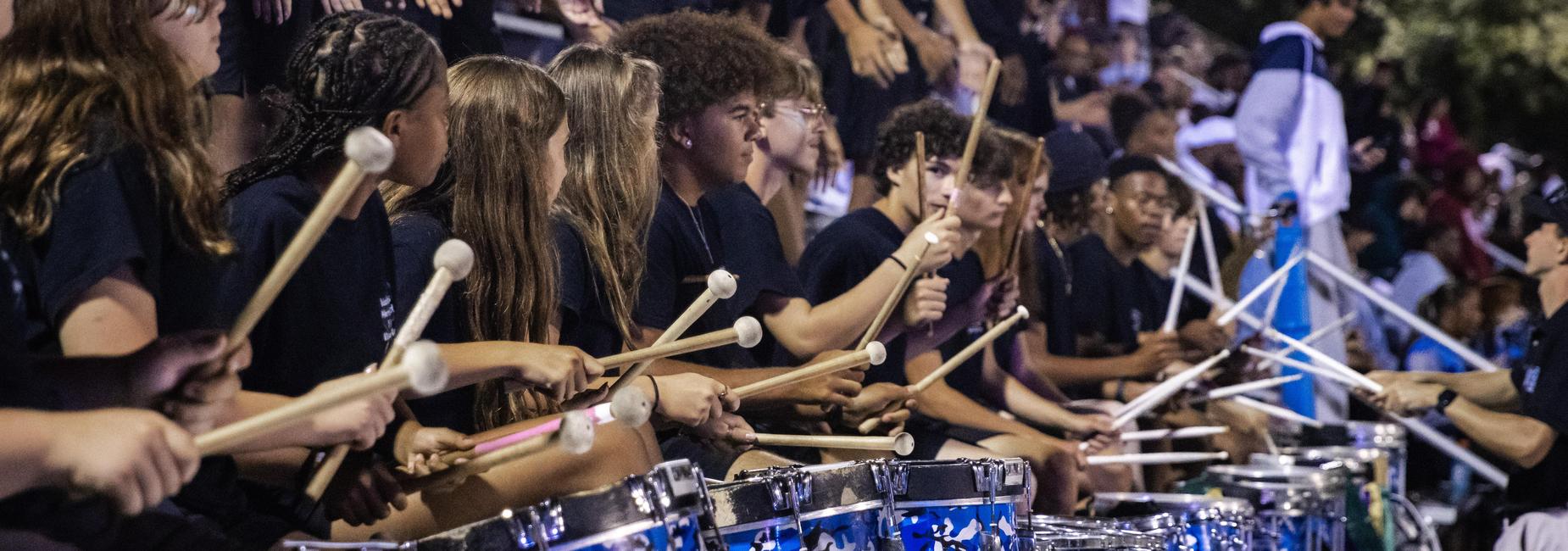 The drum line performs in the stands