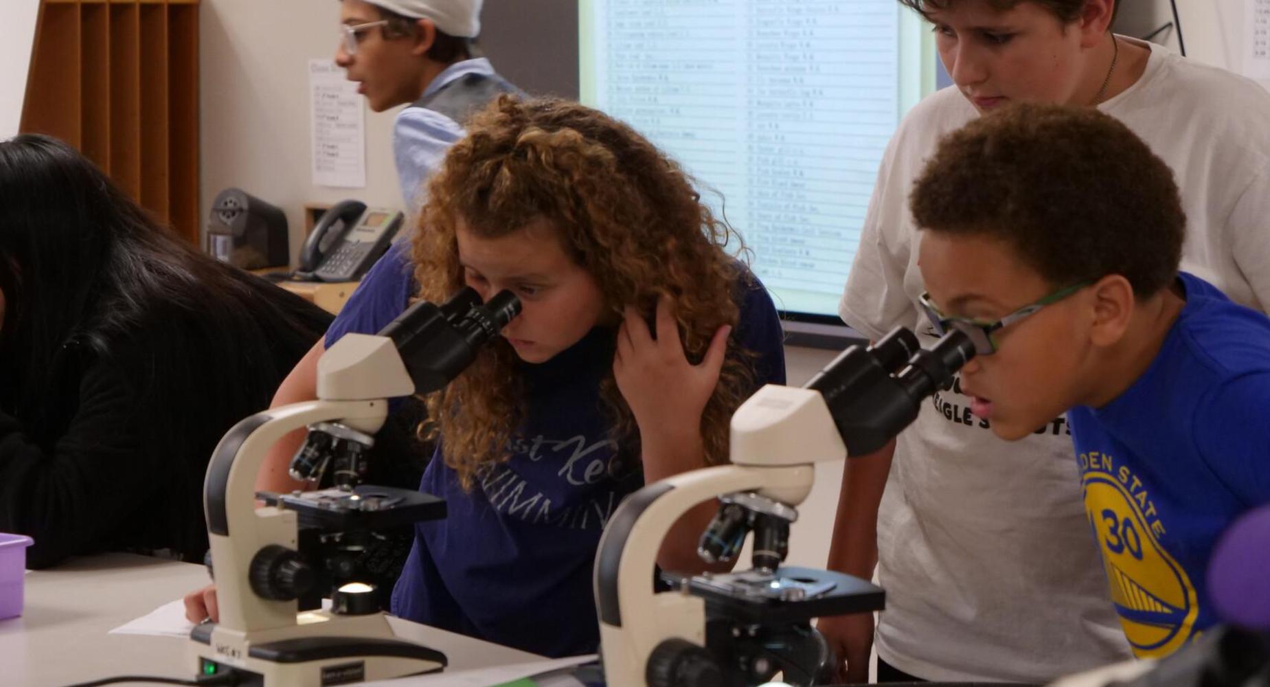 7th Grade students working with microscopes