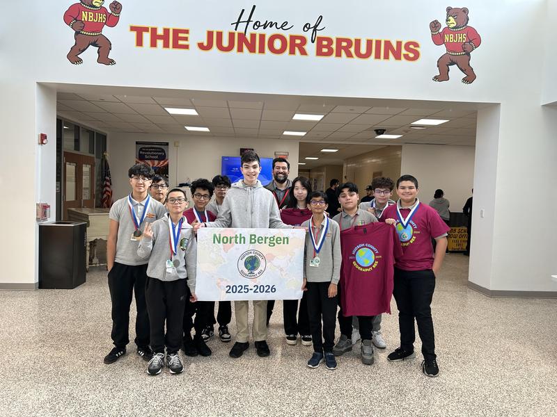 students holding up banner after geography bee