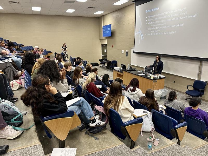 Man stands before students in crowded room