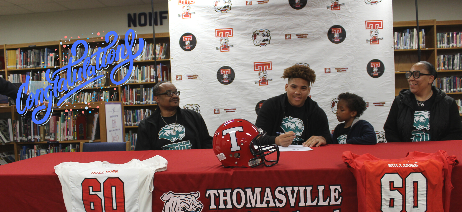 A picture of Deshawn and his family as he signs his letter of intent to play football at Greensboro College