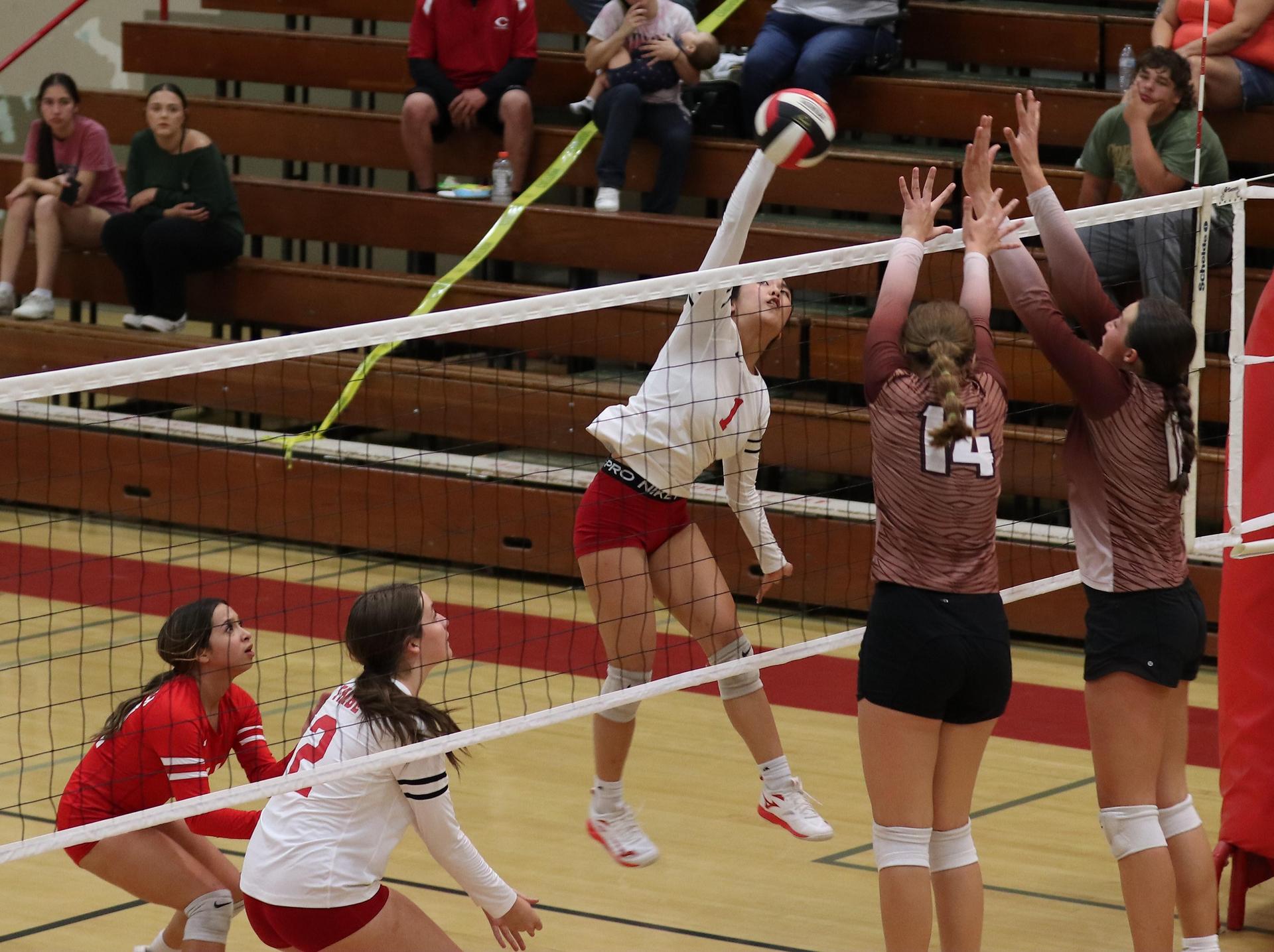 varsity volleyball players in action against Fresno Christian
