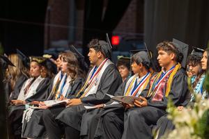 Graduates seated on stage at graduation
