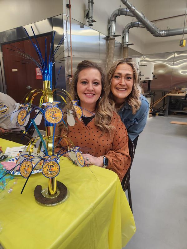 Lacey and Macy smiling during lunch at the table.