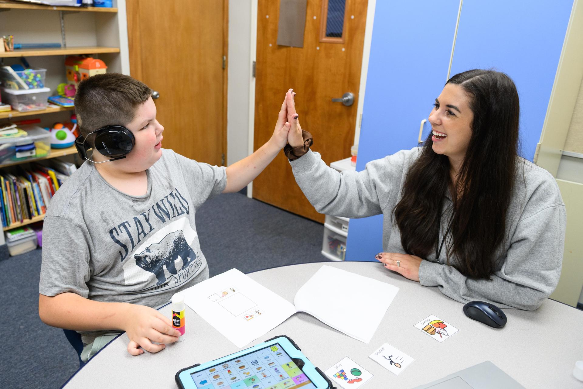 student high fiving teacher
