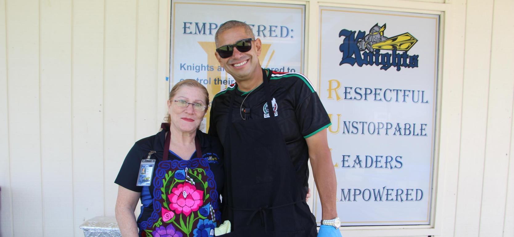 Two smiling individuals posing together in a community setting.