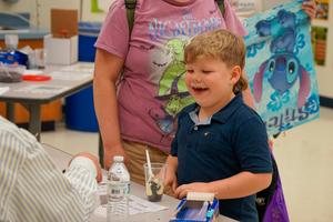 Boy smiling during station at Legacy Family Steam Night