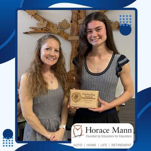student holding plaque smiling beside teacher