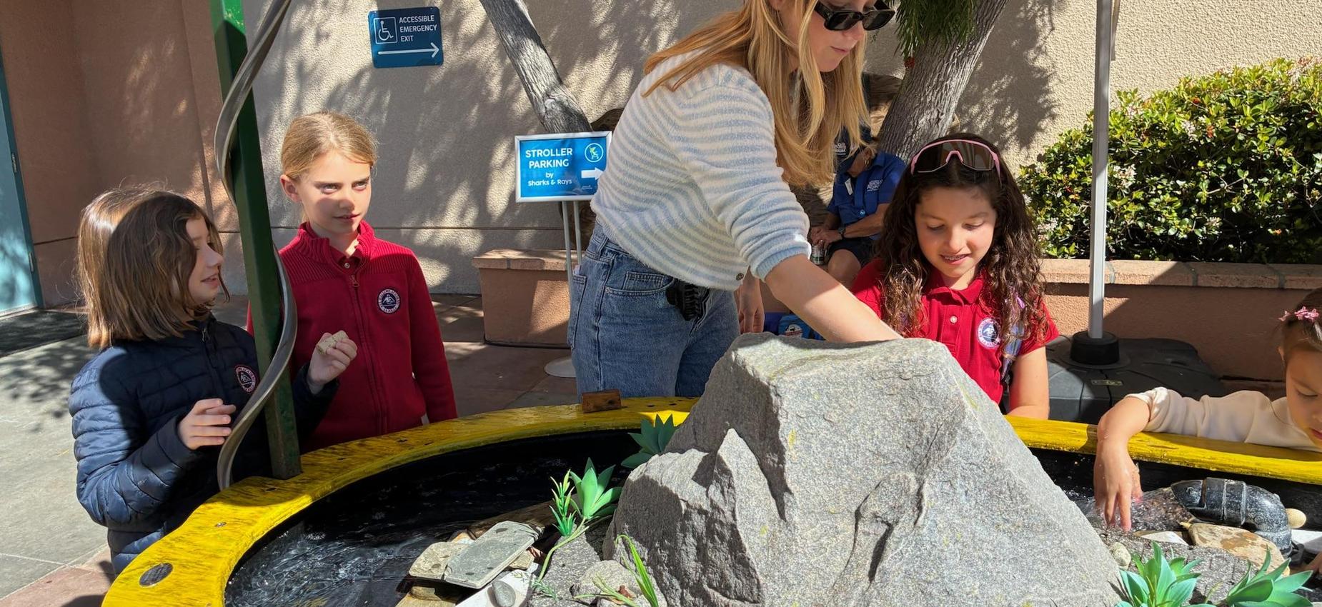 teacher points out something to student at the tide pools