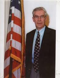 Don Collins standing next to the American flag