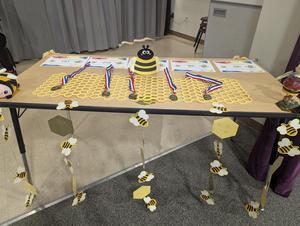 decorated table at spelling bee with certificates and medals