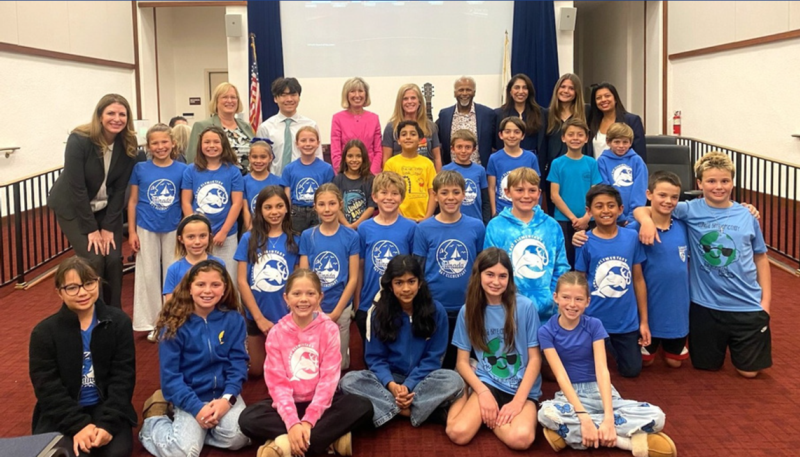 Student council members, community partner Mr. Merlin, and the Board of Education pose for a group photo
