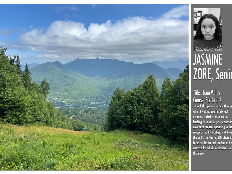 Scenic view of green mountains and valley under a cloudy blue sky.