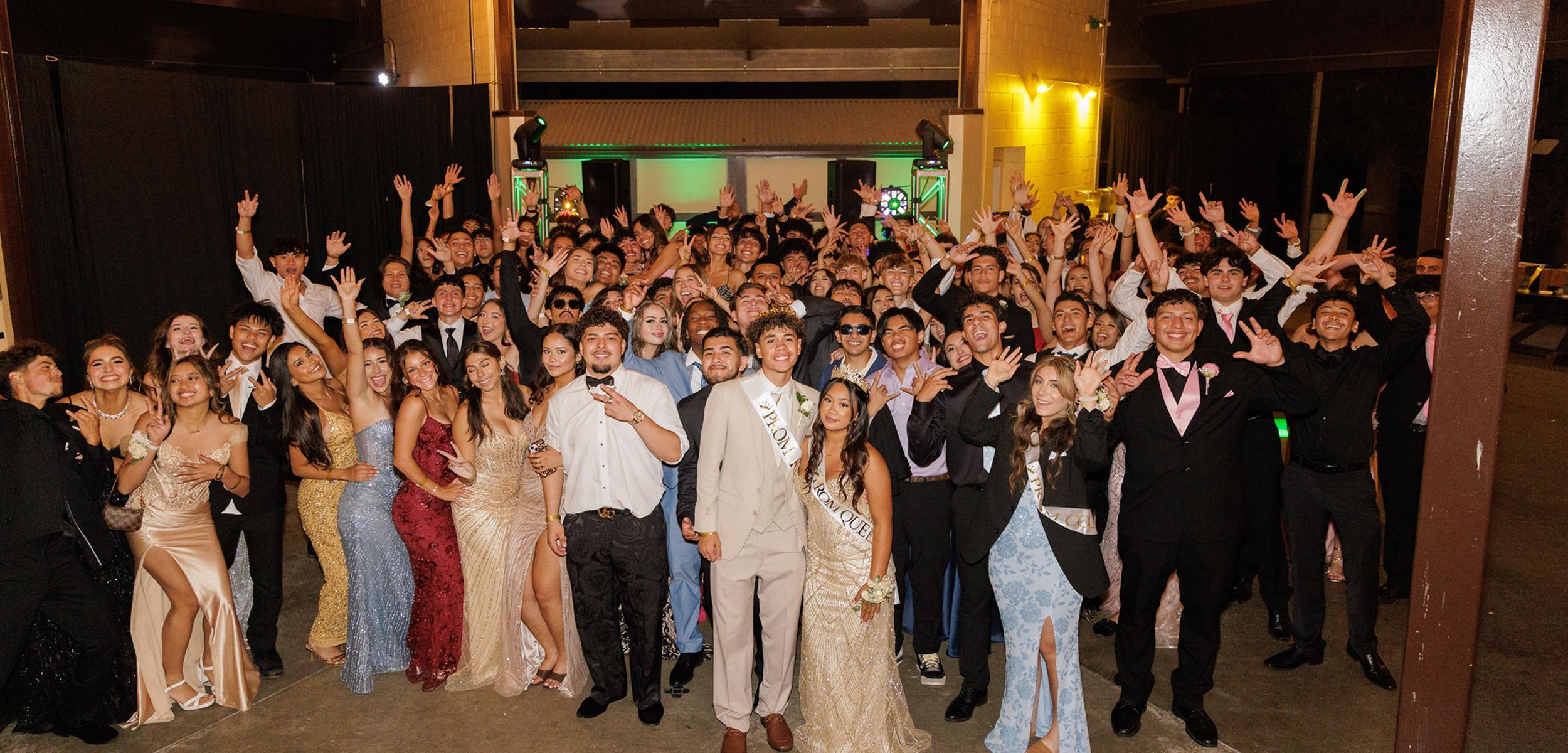 Large group of people celebrating together in formal attire.