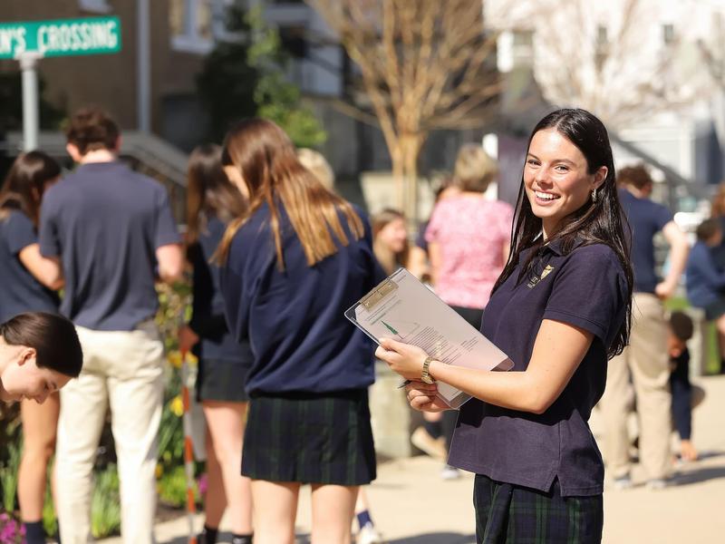 student in front of school
