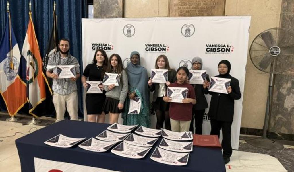 Students from the Pelham Academy Debate team with their teacher at the Bronx Borough Hall