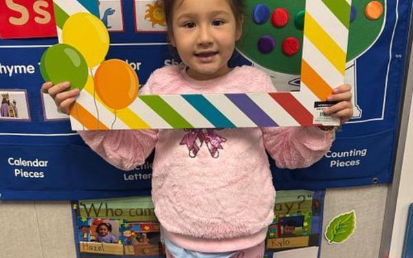 Girl holding a Happy birthday sign