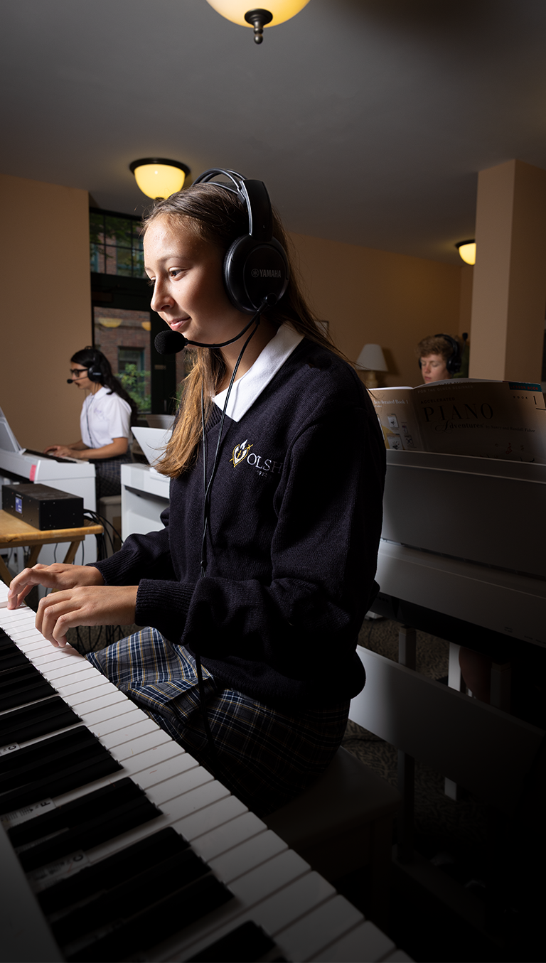 OLSH student plays a keyboard in the piano lab