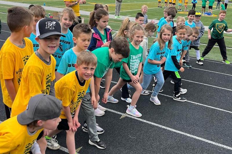 Runners from the various schools line up at Warrior Stadium for a group run
