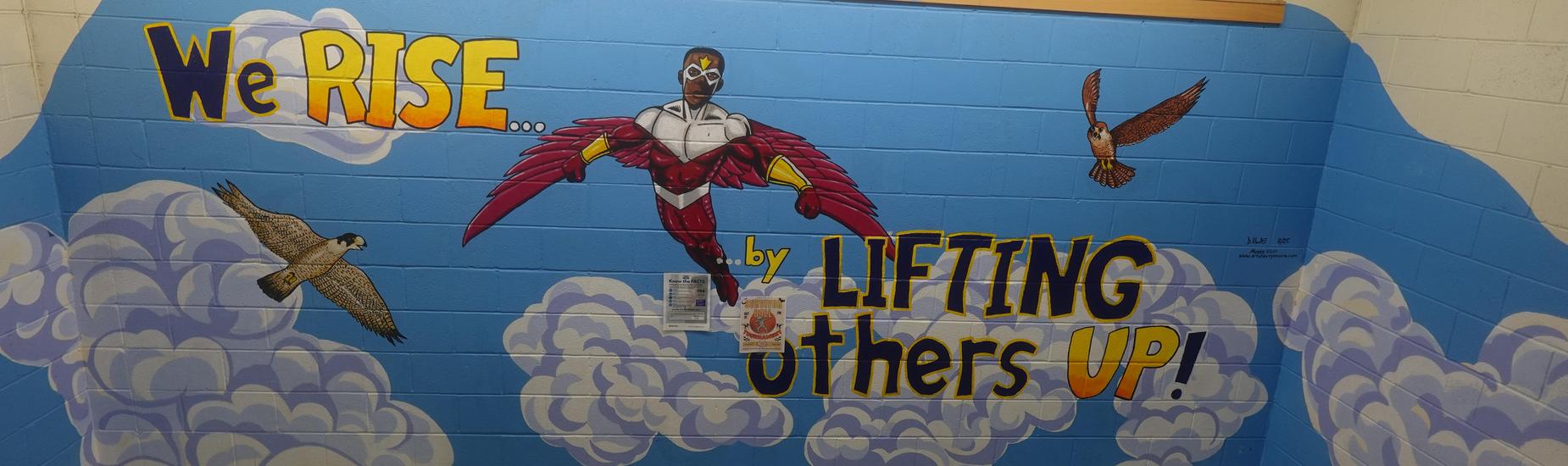 Colorful Mott Hall V stairwell mural showing a superhero-style falcon character and flying falcons with the message ‘We Rise… by Lifting Others Up