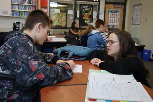 teacher working with student on an assignment