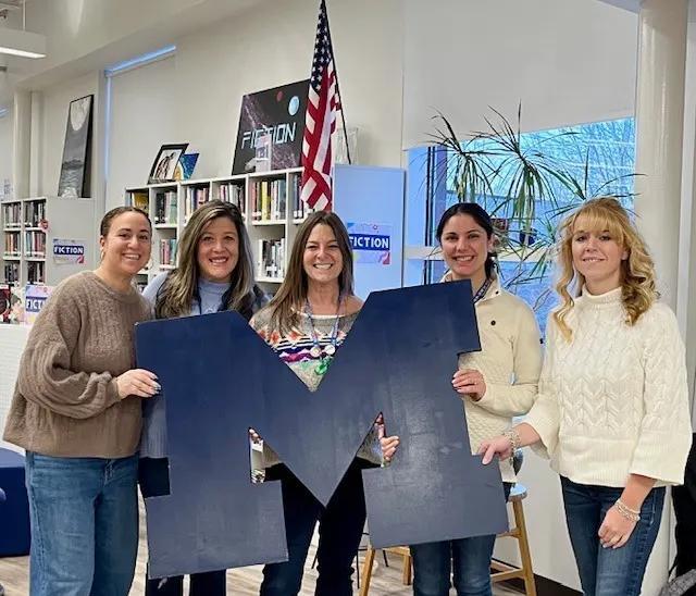 School guidance counselors holding a big Mashpee M