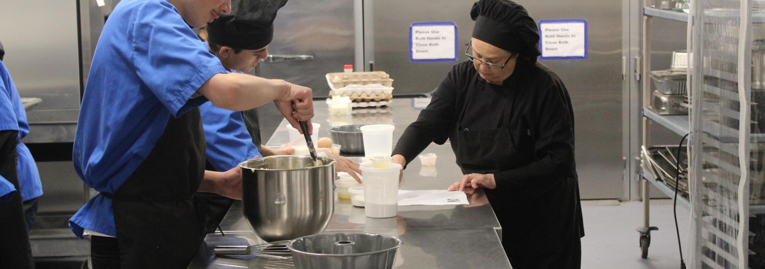 students cooking in the kitchen with instructor