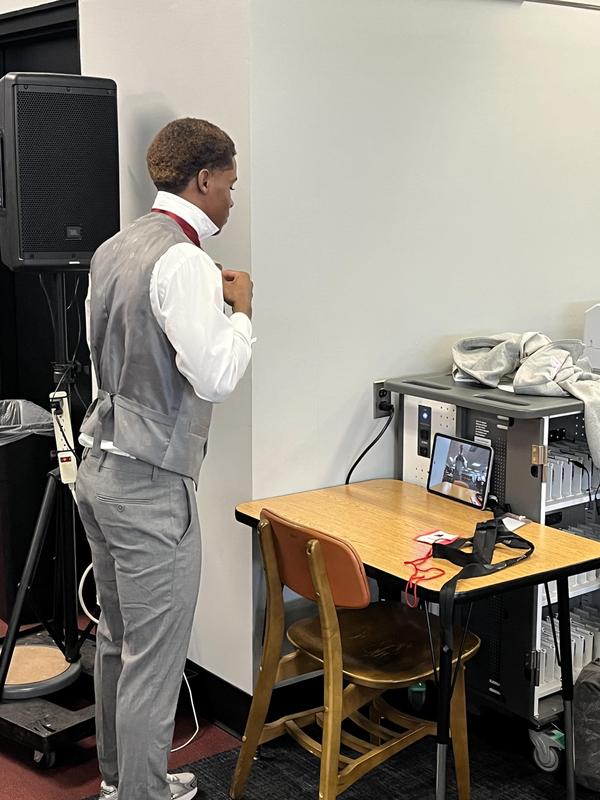 Student adjusting tie using iPad camera on table