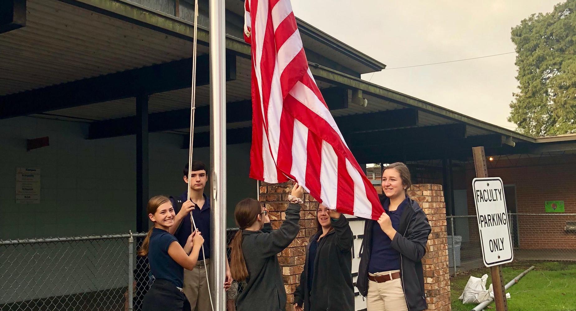 students raising the flag
