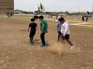students running on ridewood elementary playground making dirt devil