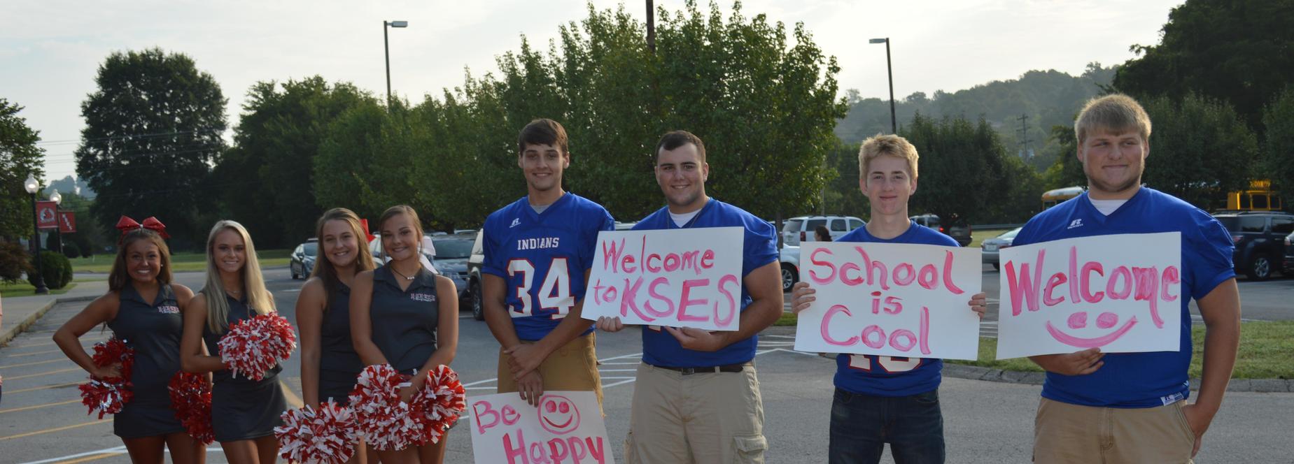 Cheerleaders and football players welcoming students back to school