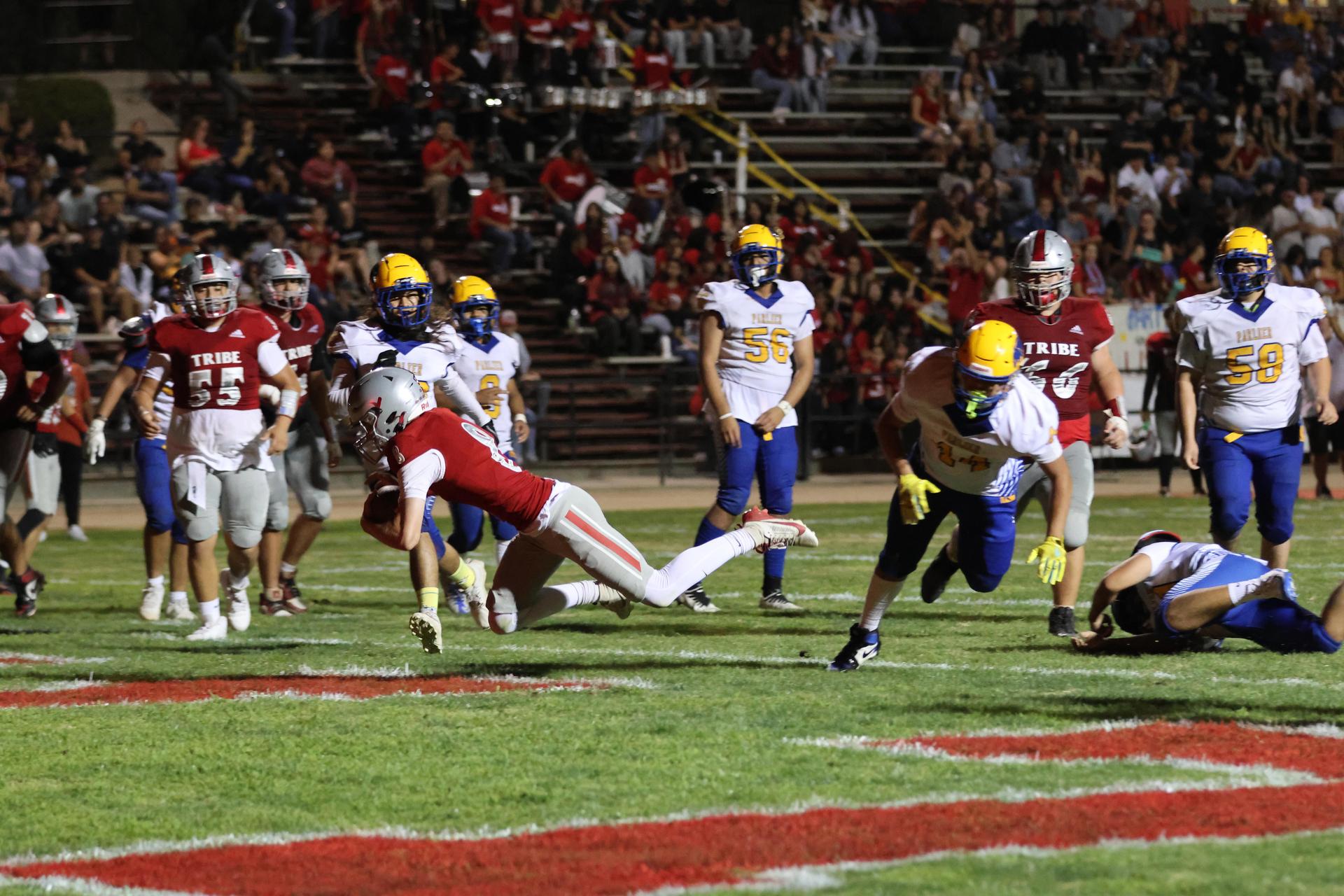 Varsity football players in action against Parlier 68