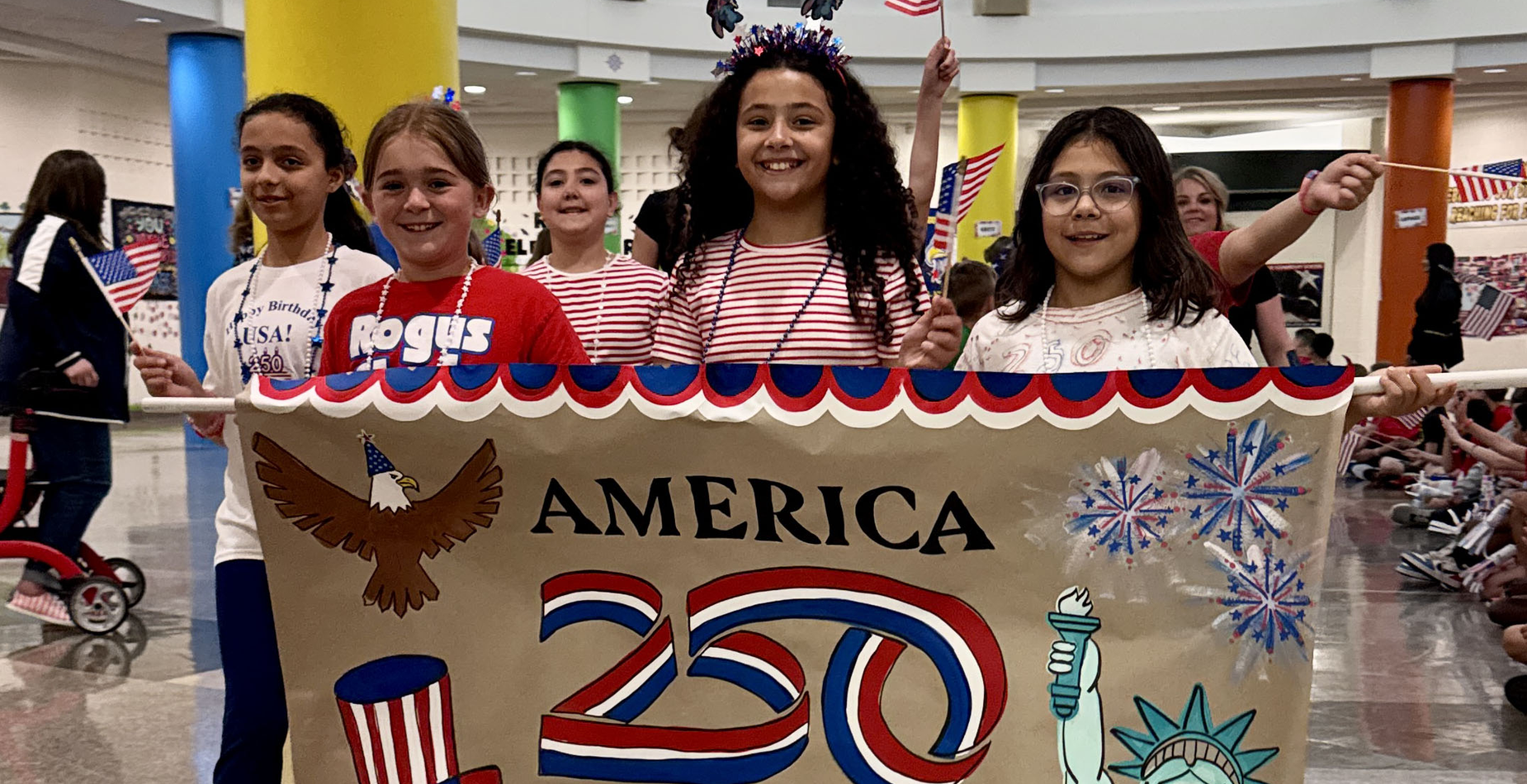 The Rogus all-school parade to celebrate the 250th anniversary of the signing of the Declaration of Independence was led by students with an America 250 banner.