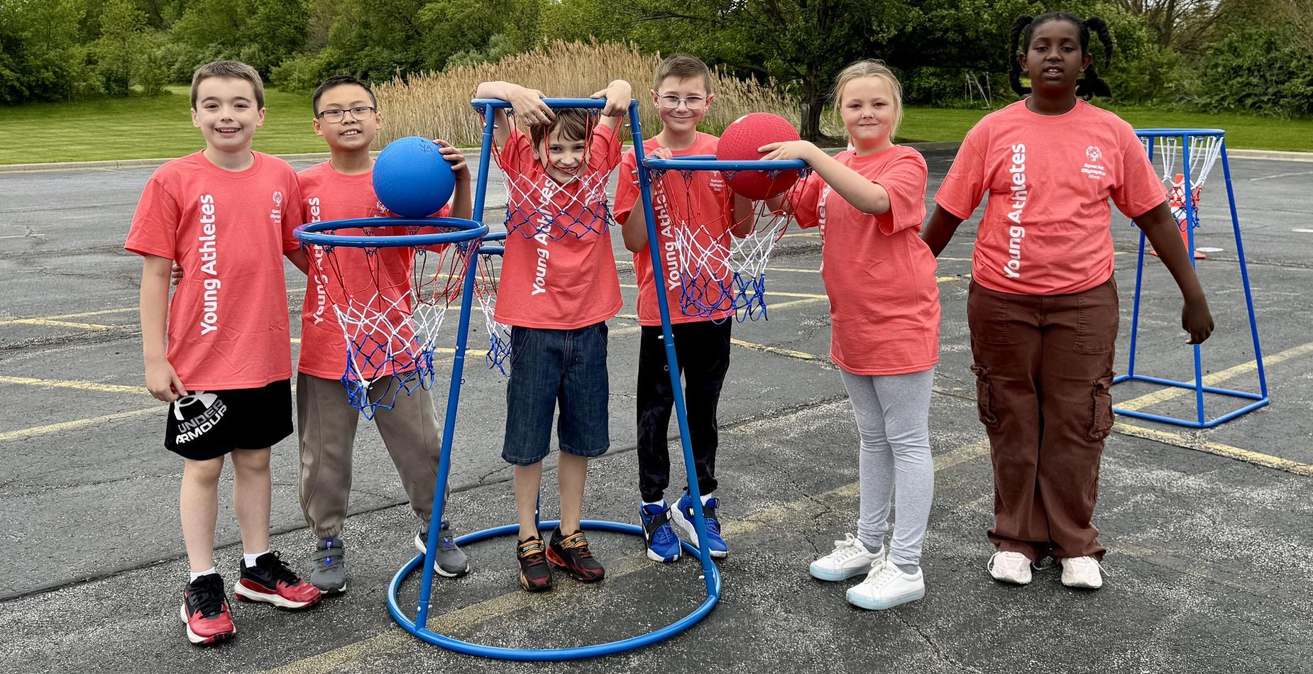 Group photo of the student helpers for the Dr. Julian Rogus School Young Athletes Event taken by the basketball hoop game.